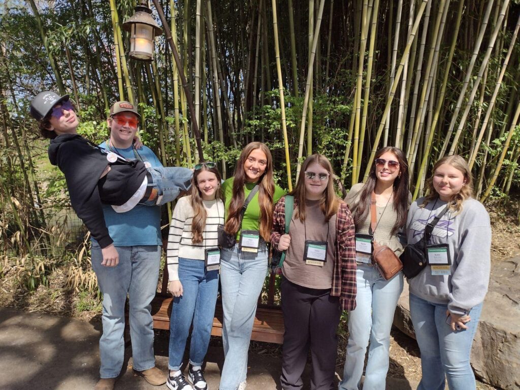 6 people in casual clothes and sunglasses posing for picture