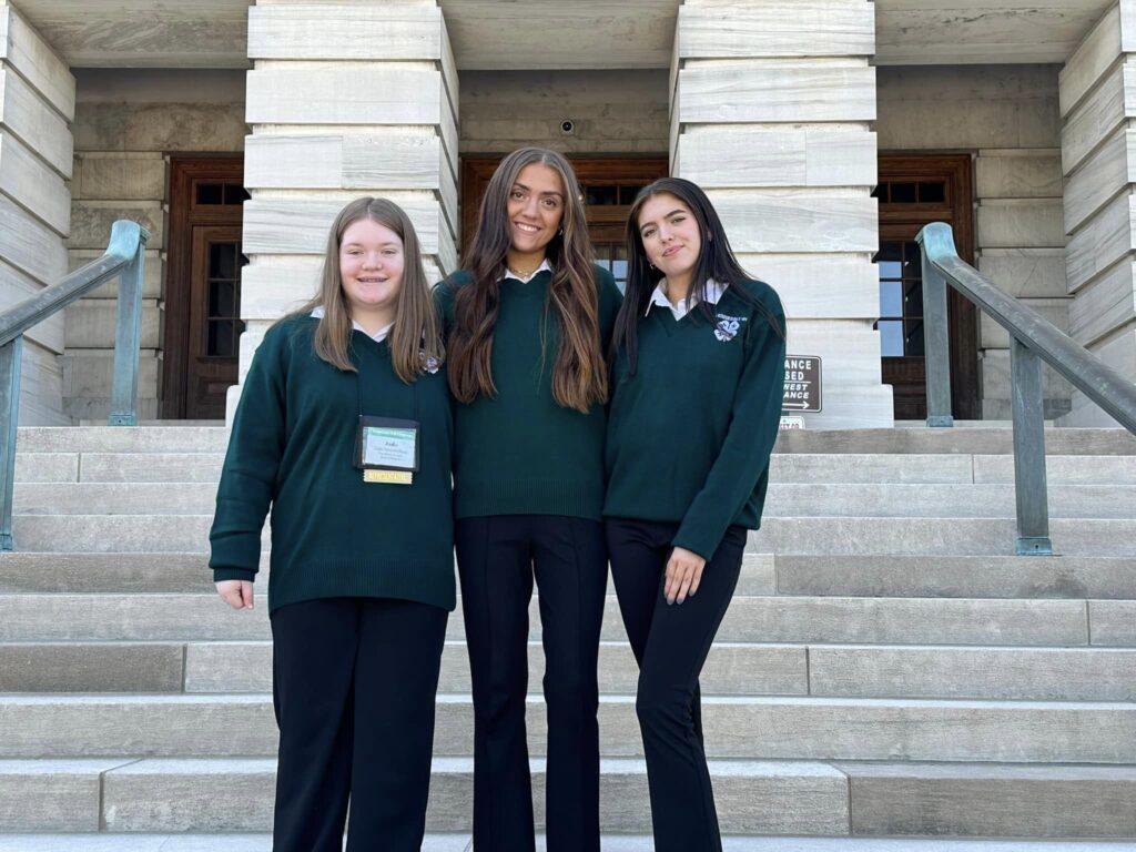 3 people smiling in front of state capitol